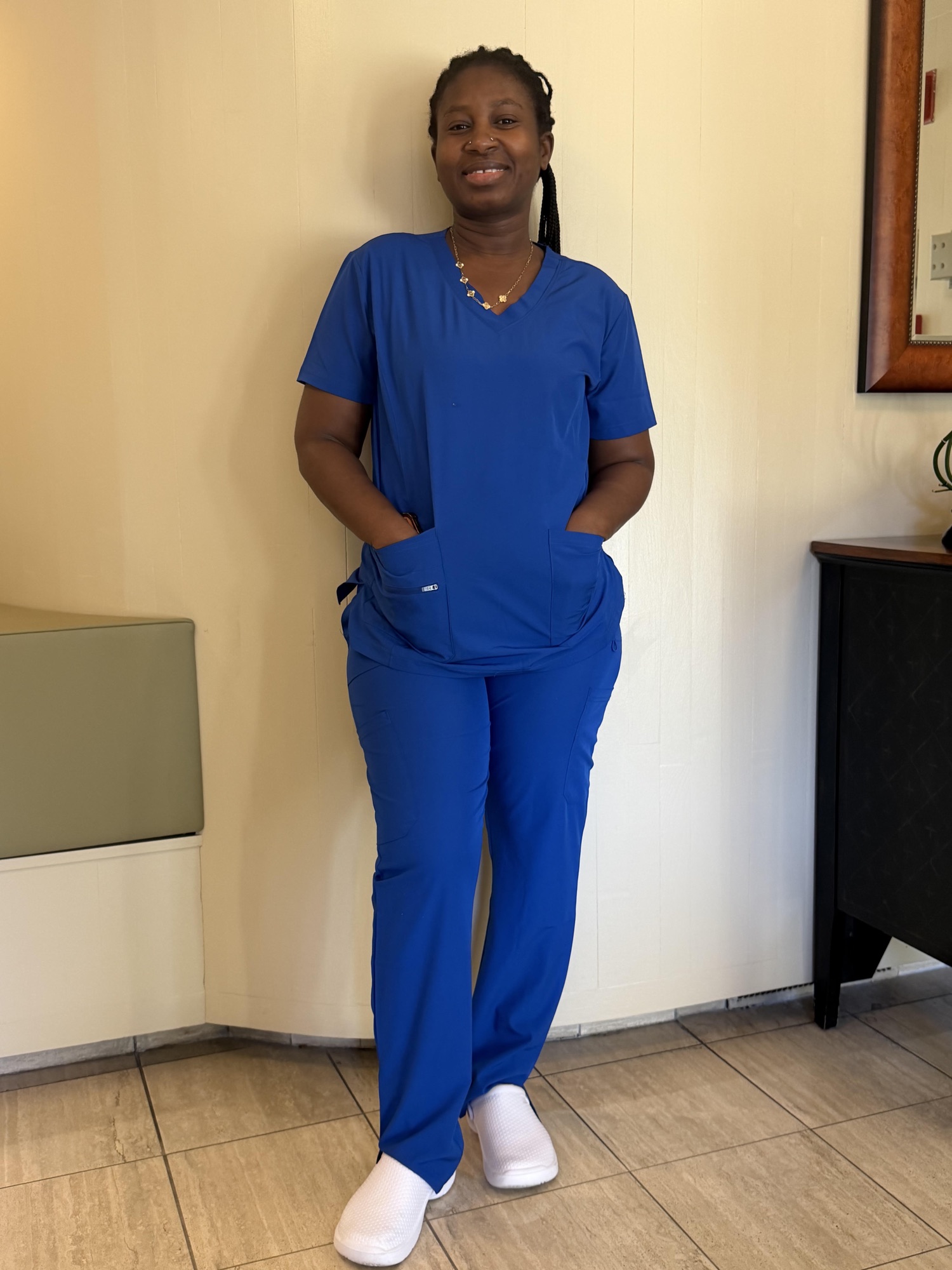 Amie, a Miracle-Lightstar caregiver, smiling in royal blue scrubs