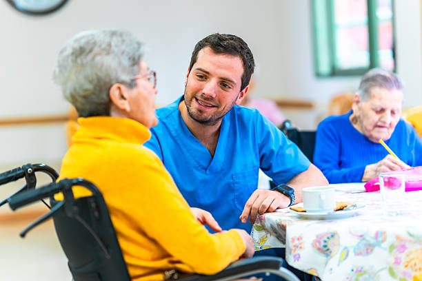 Caregiver sitting and talking warmly with an older woman over coffee