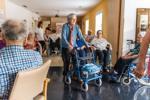 Older adults moving through a hallway with walkers and wheelchairs