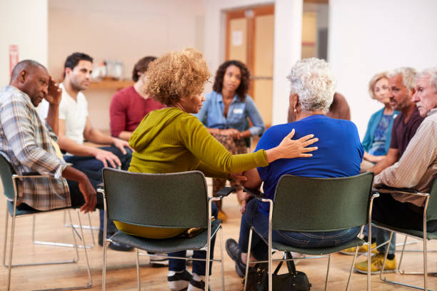 Group of adults sitting in a circle offering support to one another
